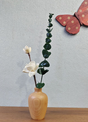 Kleine Holzvase aus Buchenholz mit bauchigem Korpus, bestückt mit weißen Blüten