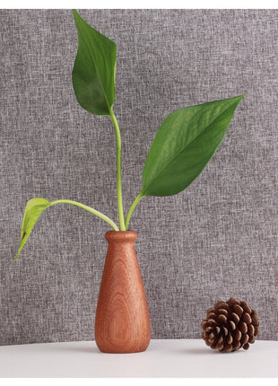 Holzvase aus Massivholz: bauchige Vase in warmem Braun mit schlanker Öffnung und Zweig