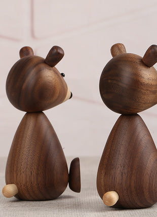 Holzbär-Figuren aus dunklem Holz, seitlich von hinten: zwei Bären mit runden Holzfüßen