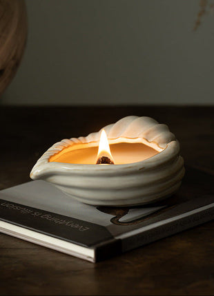 Muschel-Keramikgefäß in Schalenform, weiß, brennende Kerze