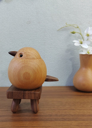Holz-Spatzfigur aus hellem Buchenholz auf dunklem Standfuß