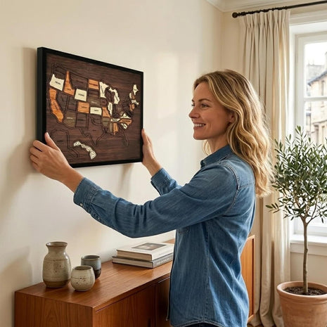 Holz-USA-Kartenpuzzle im Bilderrahmen, Frau hält das Wandbild an der Wand