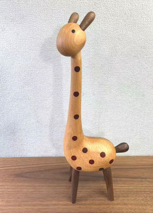 Aufrechte Giraffenfigur aus Holz mit braunen Punkten, seitlich im Stand
