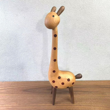 Aufrechte Giraffenfigur aus Holz mit braunen Punkten, seitlich im Stand