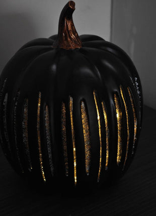 Leuchtender Glas-Kürbis in Schwarz mit goldenen Glanzstreifen und Stiel.