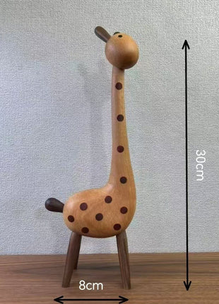 Giraffenfigur aus hellem Buchenholz mit braunen Punkten, auf drei Holzbeinen