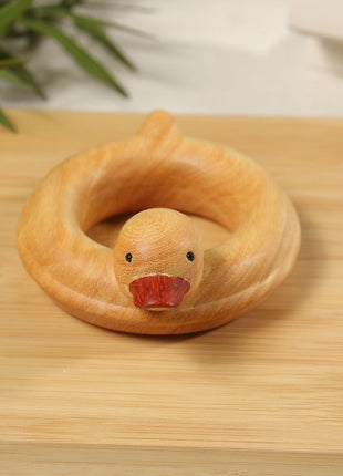 Enten-Holzskulptur im Schwimmring aus hellem Sandelholz, roter Schnabel, auf Holzbrett