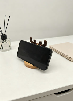 Hirsch-Handyhalter aus Holz, Smartphone liegt seitlich auf dem Sockel