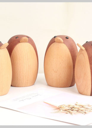 Mehrere Holzfigur-Pinguine, braun und hell, verschiedene Größen, als Deko-Ensemble