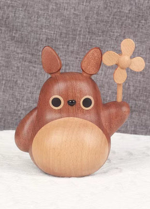 Holzfigur mit rundem Gesicht und Windrad, Totoro-ähnliche Deko aus Holz.