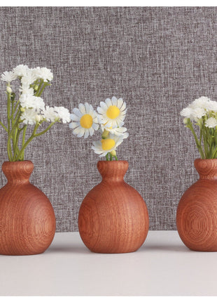 Holzvase aus Massivholz: drei runde Trockenblumenvasen in warmem Braun mit weißen Blüten