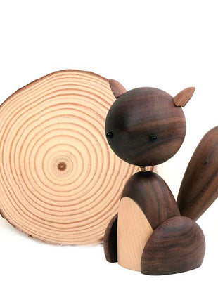 Holzfigur Eichhörnchen aus dunklem Holz auf Holzscheibe, mit hellem Bauch und aufgestelltem Schwanz