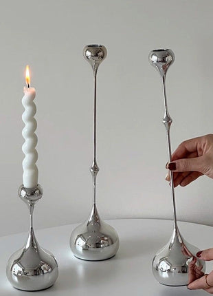 Tropfen-Kerzenhalter-Set aus silbernem Metall, drei Standfüße, eine weiße Kerze brennt