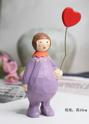 Lila Holzfigur mit Engels-Outfit, rotem Herzballon und kleinen Händen