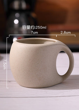 Hellbeige Steingut-Kaffeetasse auf braunem Holzuntersetzer, seitliche Ansicht