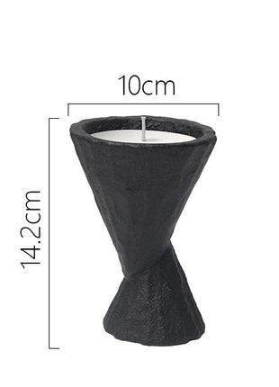 Schwarzes Kerzengefäß mit schmaler Taille und stehender Kerze