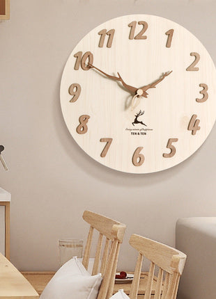 Runde Wanduhr mit hellem Ziffernblatt, Holz-Ziffern, braunen Zeigern und Hirsch-Motiv im Zentrum