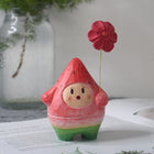 Holzfigur: roter Wassermelonen-Mensch mit roter Blume am Draht