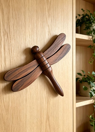 Holz-Libelle als Magnetanhänger mit vier Flügeln aus dunklem Holz, an Holzfläche