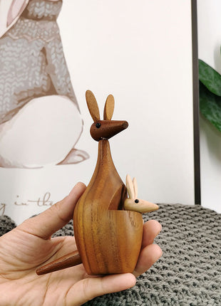 Holz-Känguru-Dekofigur in der Hand, braunes Holz mit beigem kleinem Känguru