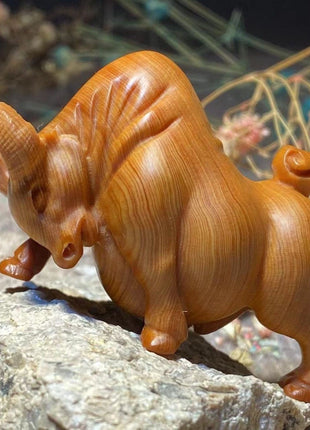 Holzfigur eines Stiers aus Thuja-Holz, orangebraun, seitlich gedreht, Hörner sichtbar, geschnitzte Beine.