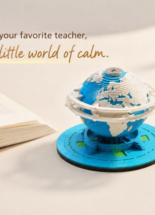 Earth paper sculpture memo pad styled beside an open book