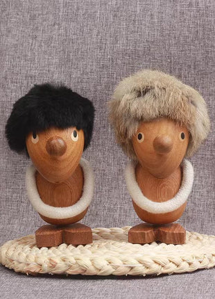 Wikinger-Figur aus Massivholz: zwei Holzpuppen mit Fellhaaren und weißem Kragen auf Flechtmatte