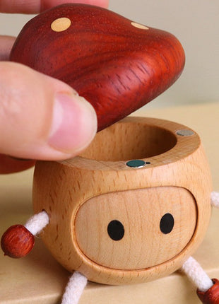 Hand hält Holz-Pilz-Aufbewahrungsbox; Hut mit Punkten, Gesicht mit schwarzen Augen