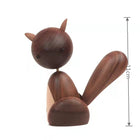 Holzfigur Eichhörnchen aus dunklem Holz mit hellem Bauch, Schwanz nach oben, seitlich