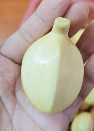 Bananenförmige Holzfigur, hellgelb, in der Hand gehalten, glatte Oberfläche