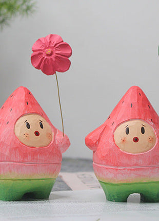 Handgeschnitzte Holzfigur: zwei Wassermelonen-Menschen mit roter Blume und grünem Ballon