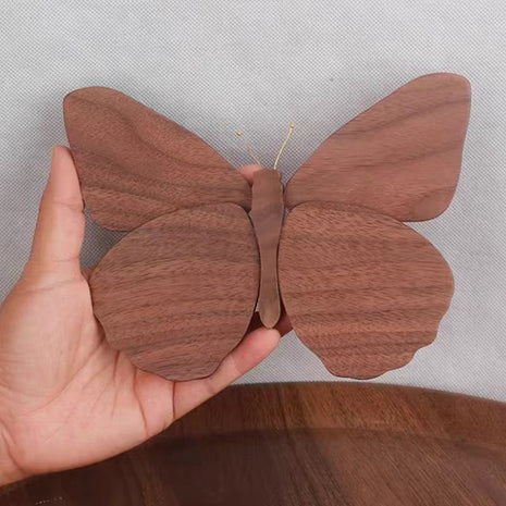 Schmetterlingsdeko aus Massivholz in brauner Holzoptik, von einer Hand gehalten