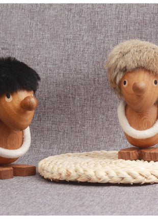 Wikinger-Figur aus Massivholz: zwei Holzpuppen mit Fellhaaren und weißem Kragen auf Flechtmatte