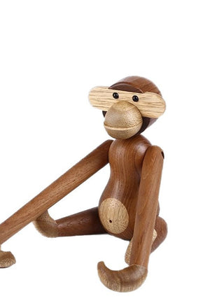 Gelenkige Holzskulptur als Affe im seitlichen Sitzen mit erhobenem Arm