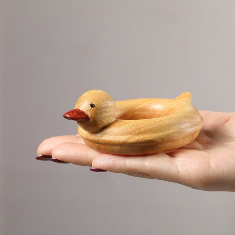 Enten-Holzskulptur im Schwimmring aus hellem Sandelholz, roter Schnabel, in Händen gehalten