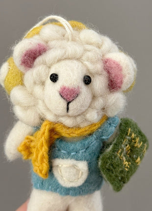 Close-up of reading sheep charm with yellow headphones and a green felt book