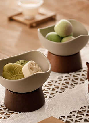 Zwei Dessertschalen aus Keramik auf Standfuß: cremefarbene Schalen, gefüllt mit Snacks
