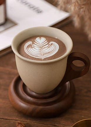 Kaffeetasse aus Keramik mit Holzuntersetzer, beige Tasse, Latte-Art und braunes Holz
