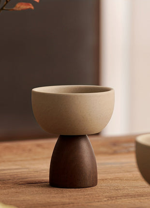 Kleine Steingut-Kaffeetasse, beiger Schalenbecher auf dunklem Standfuß