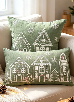 Light green Christmas village embroidered pillows on a sofa