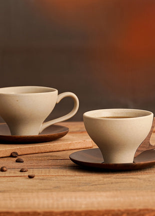Keramiktasse-Set mit zwei Tassen in hellem Beige und braunen Untersetzern