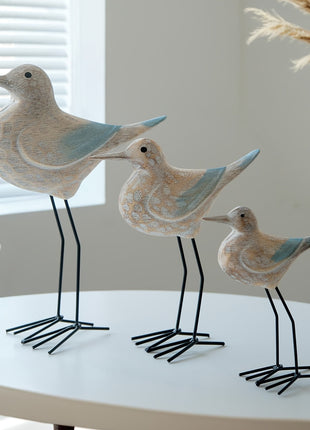 Holz-Seevogel-Ornament mit blauen Flügelakzenten, drei stehende Vögel auf Metallbeinen