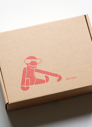 Karton-Versandbox mit rotem Affenaufdruck und Schriftzug „Monkey“.