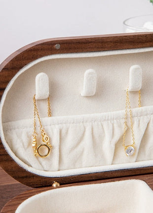 Ovale Schmuckbox mit Samteinlage und Kettenfächern; goldfarbene Ketten mit Anhänger