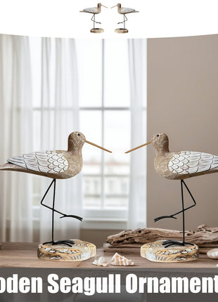 2er-Set Möwen-Holzfiguren mit Flügel-Schuppenmuster und schwarzen Metallbeinen vor Fensterblick