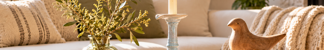 Warm Nordic living room vignette with ceramic candleholder, wooden sculptures and crystal stones