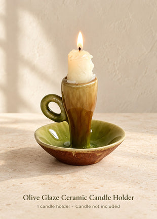 Olive green and brown glazed ceramic candle holder with loop handle and saucer base; one holder, candle not included