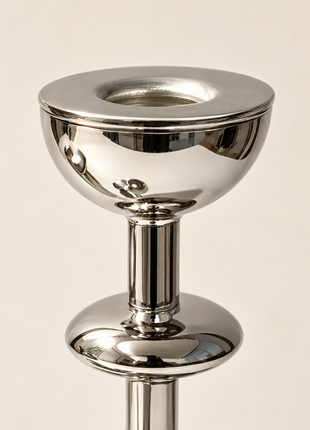 Close-up of the silver-tone candle holder showing its circular candle opening, bowl rim and reflective metal finish.